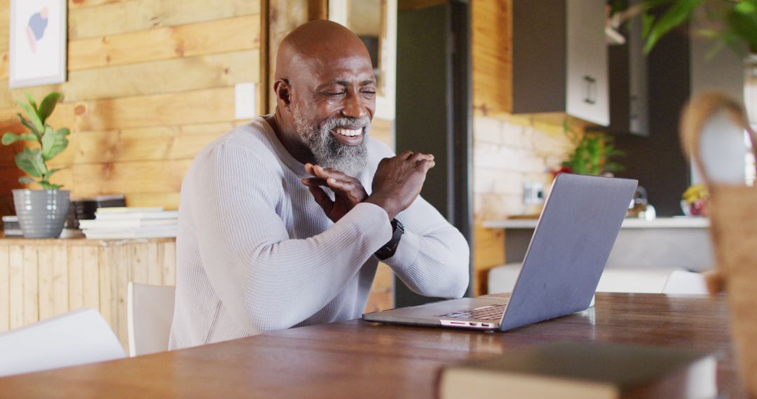 Mature Man Smiling During Video Call on Laptop in Cozy Home - Free Images, Stock Photos and Pictures on Pikwizard.com