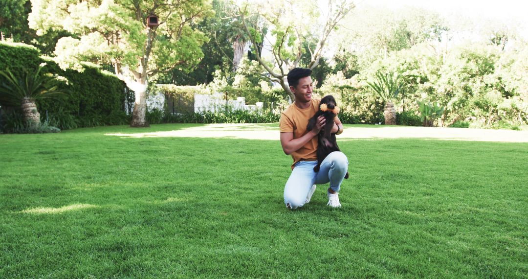 Man Enjoying Leisure Time with Puppy in Sunny Green Garden