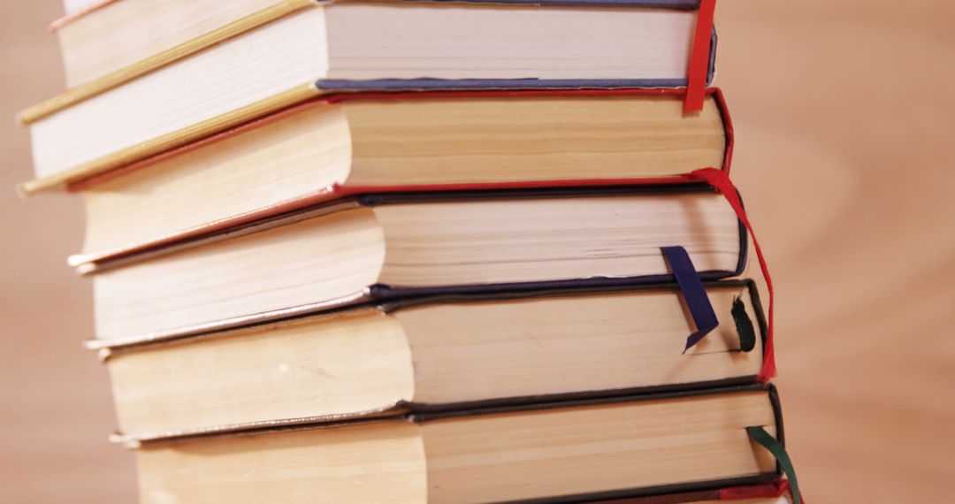 Stack of books with bookmarks on wooden desk