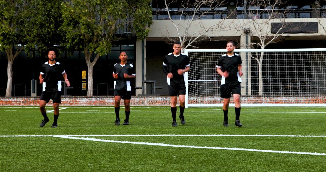 Soccer Players Warming Up with High Knees in Black Uniforms