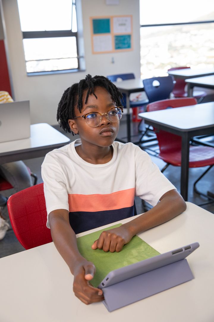 Focused Child Engaging with Tablet in Modern Classroom