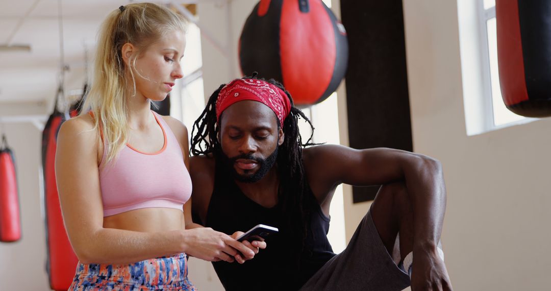 Female Athlete with Coach Reviewing Fitness Data at Gym - Free Images, Stock Photos and Pictures on Pikwizard.com