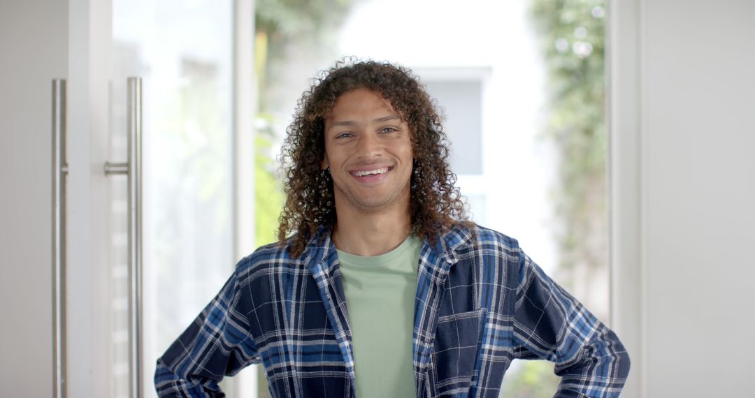 Portrait of happy biracial man with long curly dark hair in doorway at home - Free Images, Stock Photos and Pictures on Pikwizard.com