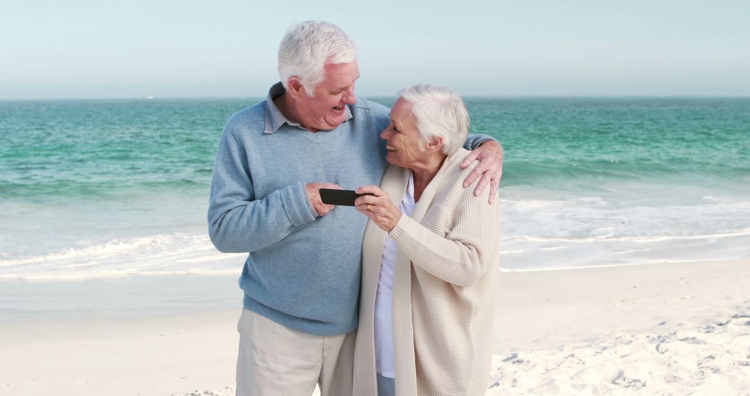 Happy Senior Couple Taking Photos on Beach, Retirement, Vacation Memories - Free Images, Stock Photos and Pictures on Pikwizard.com