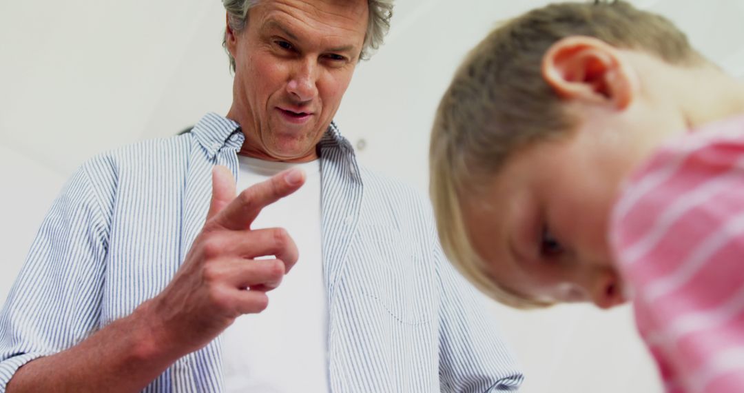 Stern Father Pointing Finger at Young Child Indoors - Free Images, Stock Photos and Pictures on Pikwizard.com