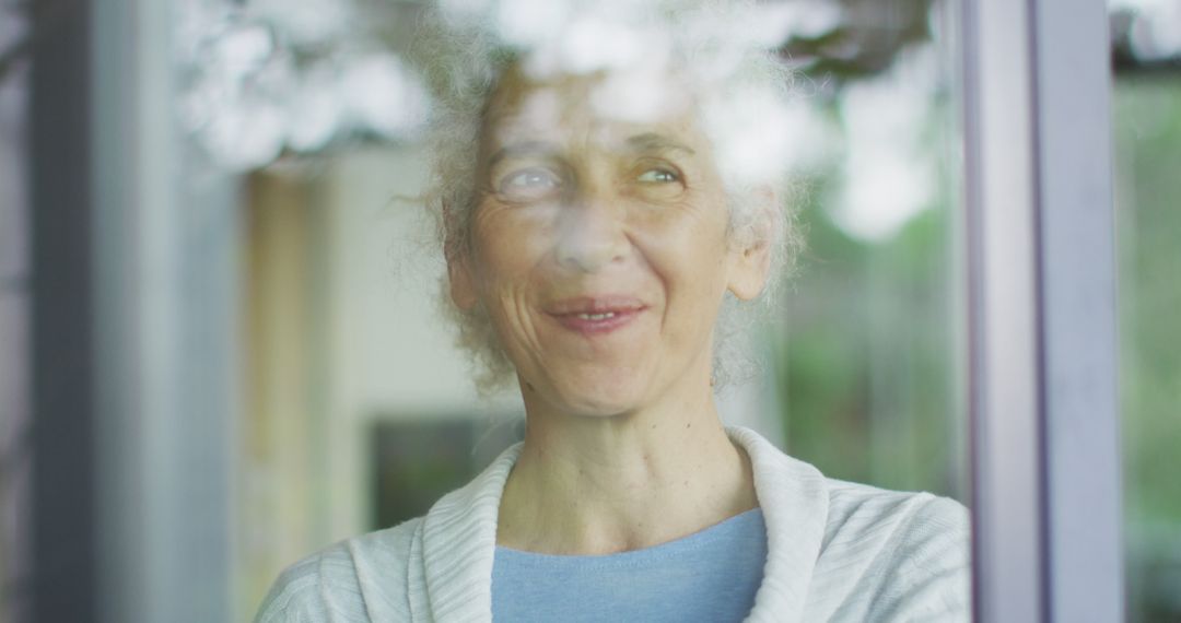 Smiling Senior Woman Looking Out Window with Gentle Expression - Free Images, Stock Photos and Pictures on Pikwizard.com