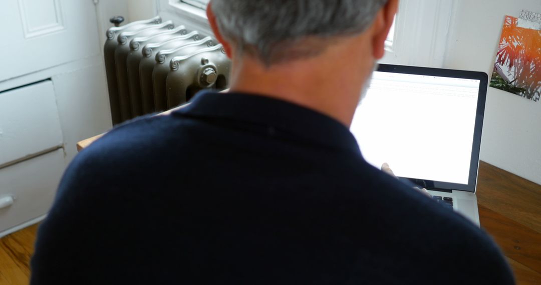 Middle-aged Man Working on Laptop from Home Office - Free Images, Stock Photos and Pictures on Pikwizard.com