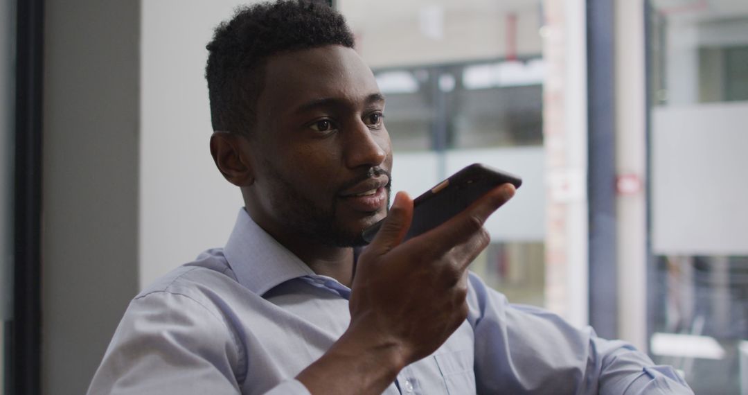 Businessman Using Voice Command on Smartphone in Office - Free Images, Stock Photos and Pictures on Pikwizard.com