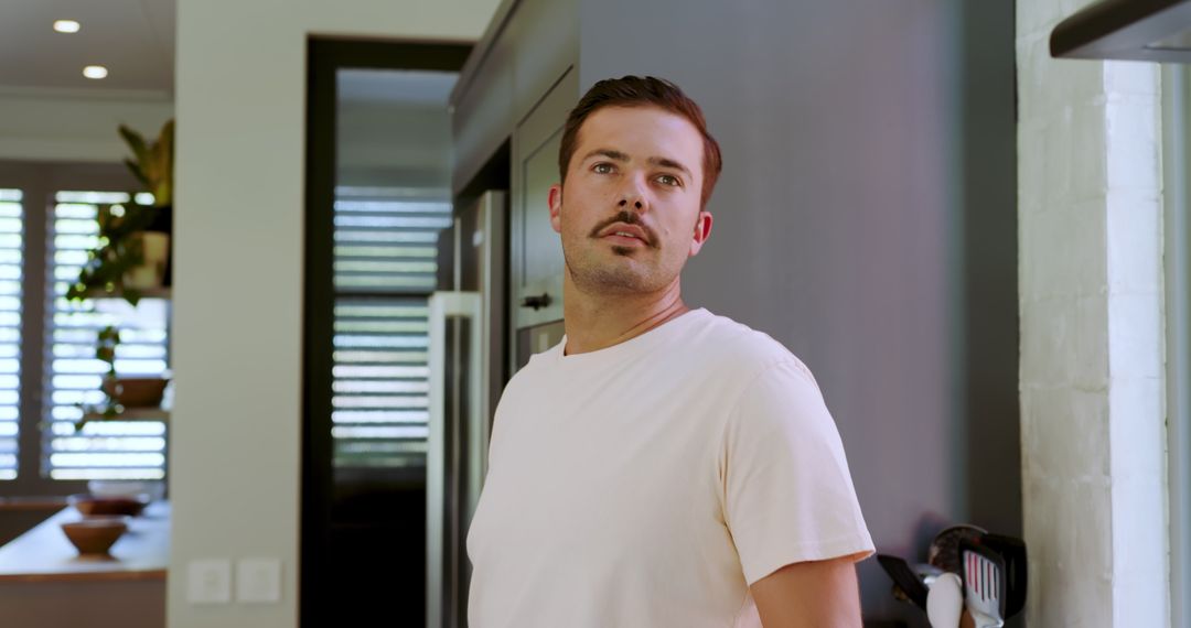 Contemplative Man Relaxing in Modern Minimalist Kitchen