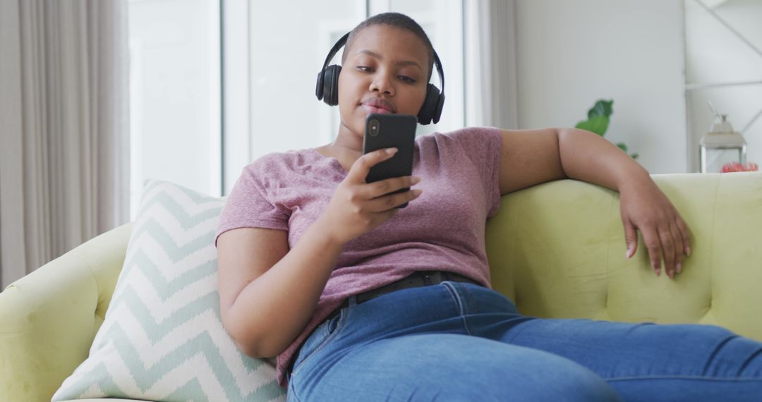 Young Adult Relaxing on Couch with Headphones and Smartphone - Free Images, Stock Photos and Pictures on Pikwizard.com