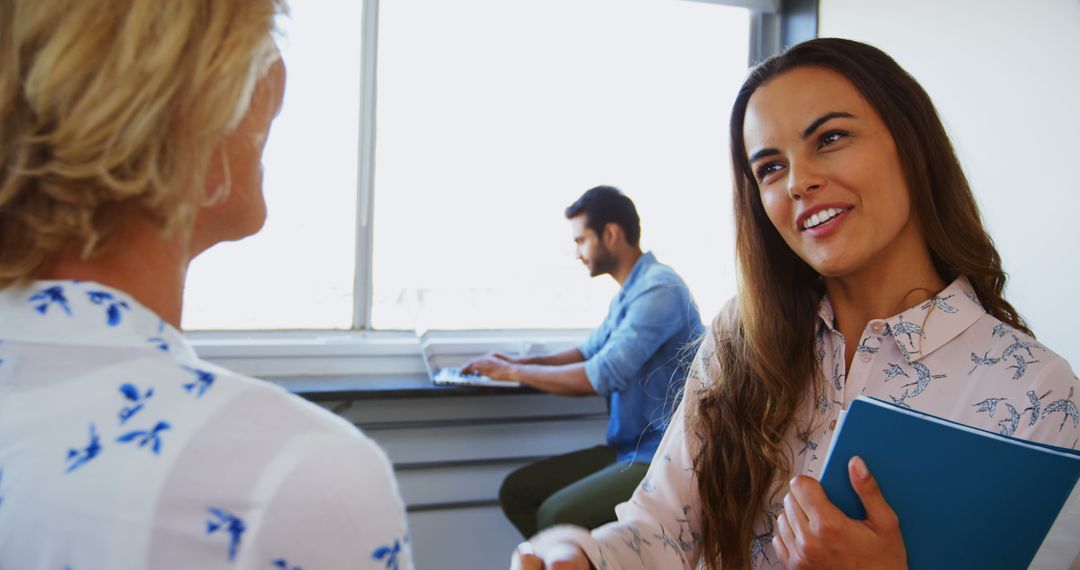 Colleagues Discussing Ideas in Bright Office with Man Working