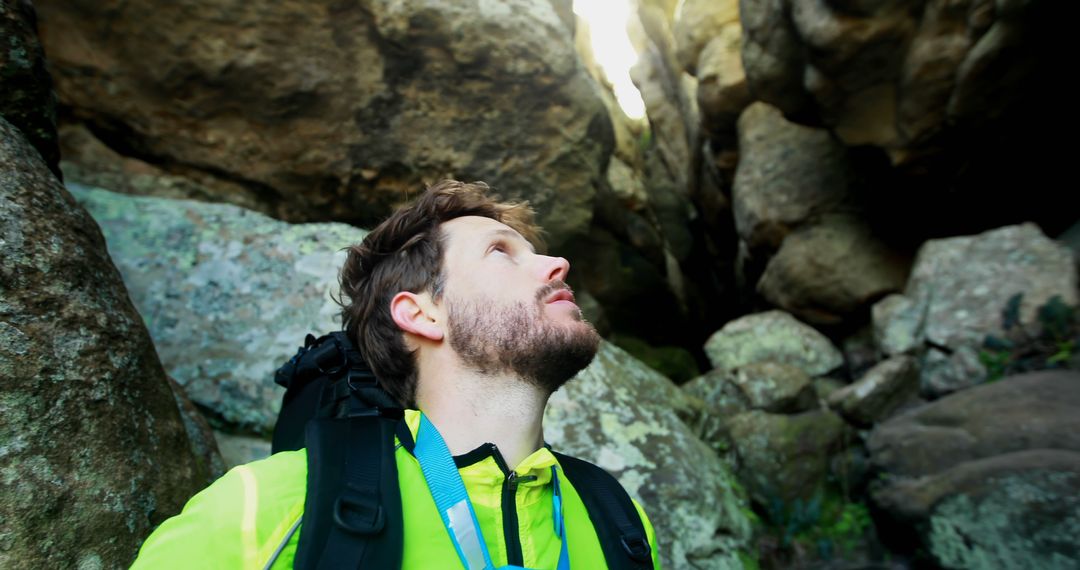 Male hiker admiring rugged rock formations in sunlight - Free Images, Stock Photos and Pictures on Pikwizard.com