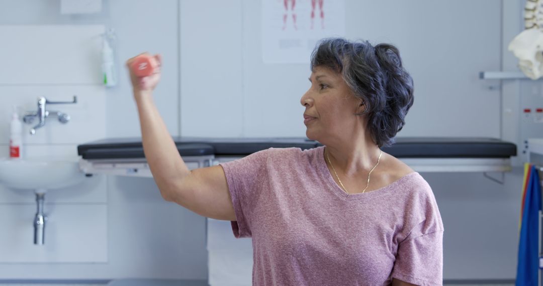 Senior Woman Exercising with Dumbbell in Physiotherapy Clinic - Free Images, Stock Photos and Pictures on Pikwizard.com