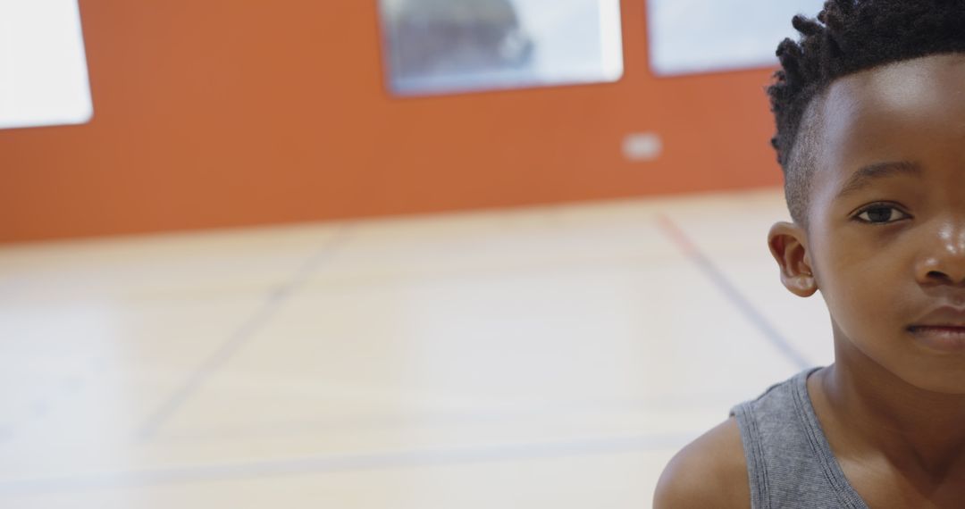 Young Boy in Gym Setting with Focus on Floor and Classroom Style