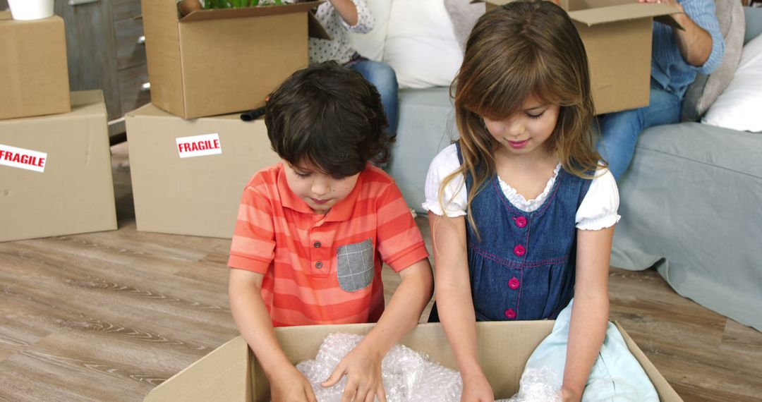 Children Packing Belongings in Cardboard Boxes During Moving Day - Free Images, Stock Photos and Pictures on Pikwizard.com