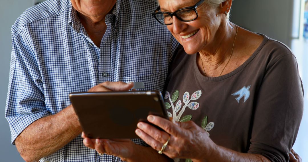 Senior Couple Enjoying Digital Entertainment on Tablet