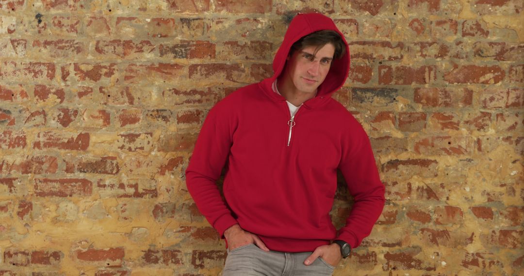 Young Man in Red Hoodie Posing Against Brick Wall - Free Images, Stock Photos and Pictures on Pikwizard.com