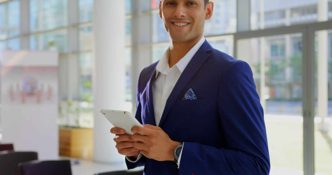 Confident young professional holding smartphone in modern office