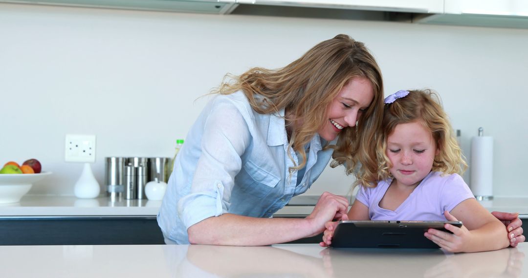 Mother and Daughter Using Tablet in Modern Kitchen - Free Images, Stock Photos and Pictures on Pikwizard.com