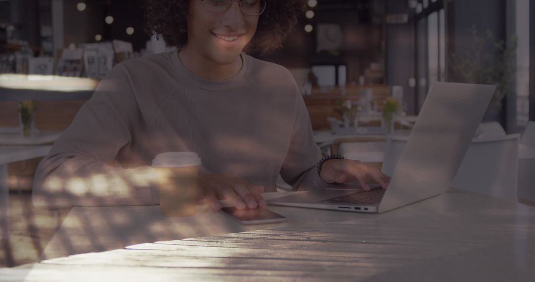 Smiling Woman Using Laptop in Busy Cafe Setting