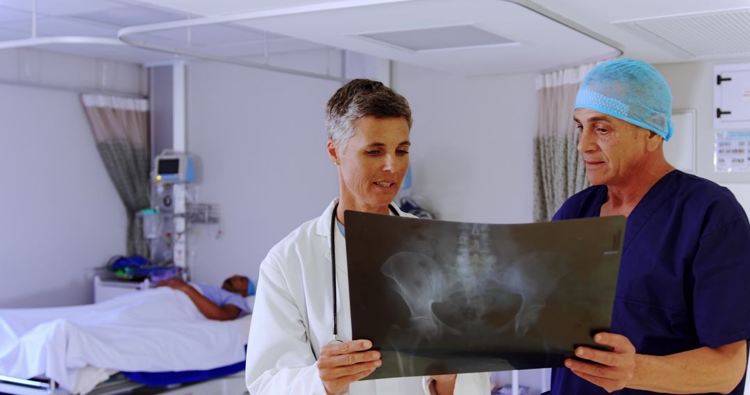 Doctors Analyzing X-ray in Hospital Room, Patient in Background - Free Images, Stock Photos and Pictures on Pikwizard.com