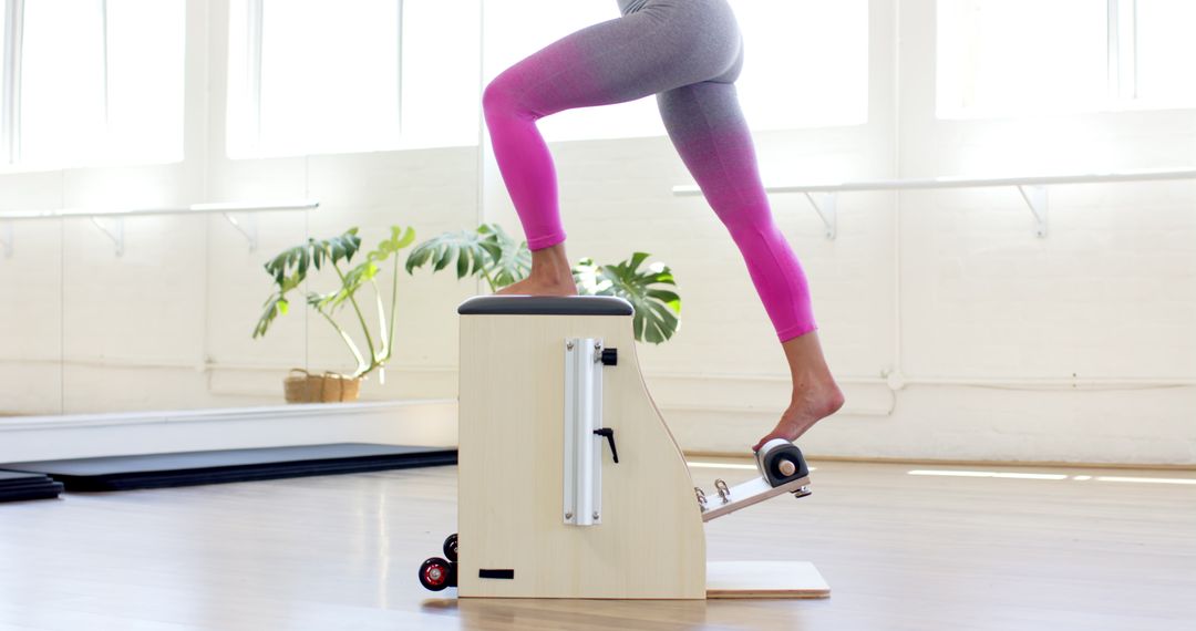 Woman Exercising on Pilates Wunda Chair in Bright Studio