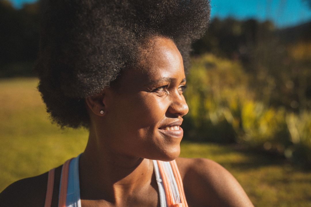 African American Woman Smiling Outdoors in Sunlight - Free Images, Stock Photos and Pictures on Pikwizard.com