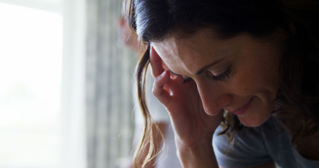 Woman Stressed and Thinking Deeply at Home Next to Window - Free Images, Stock Photos and Pictures on Pikwizard.com