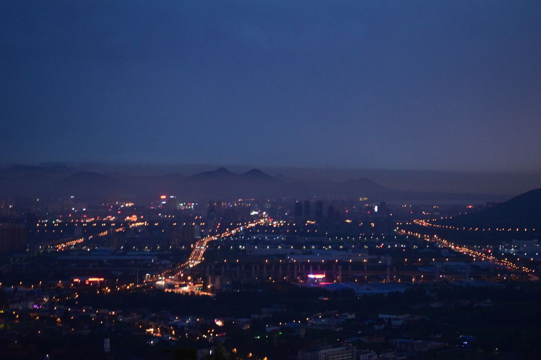 Twilight Cityscape with Illuminated Roads and Distant Mountains - Free Images, Stock Photos and Pictures on Pikwizard.com