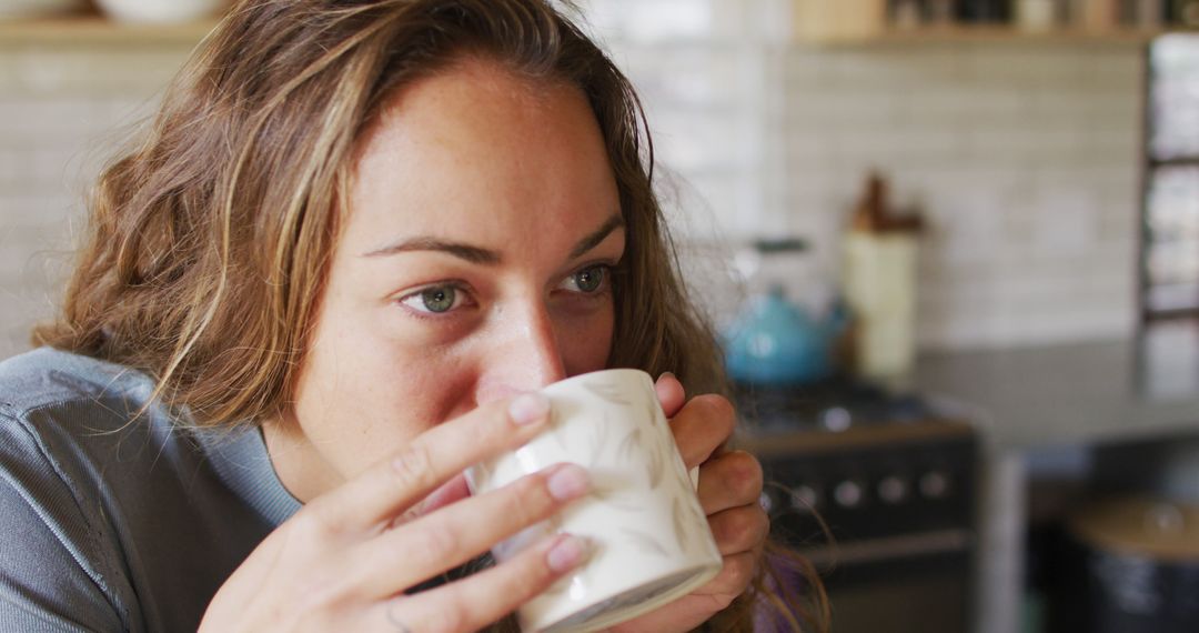 Woman Enjoying Hot Beverage in Cozy Kitchen - Free Images, Stock Photos and Pictures on Pikwizard.com