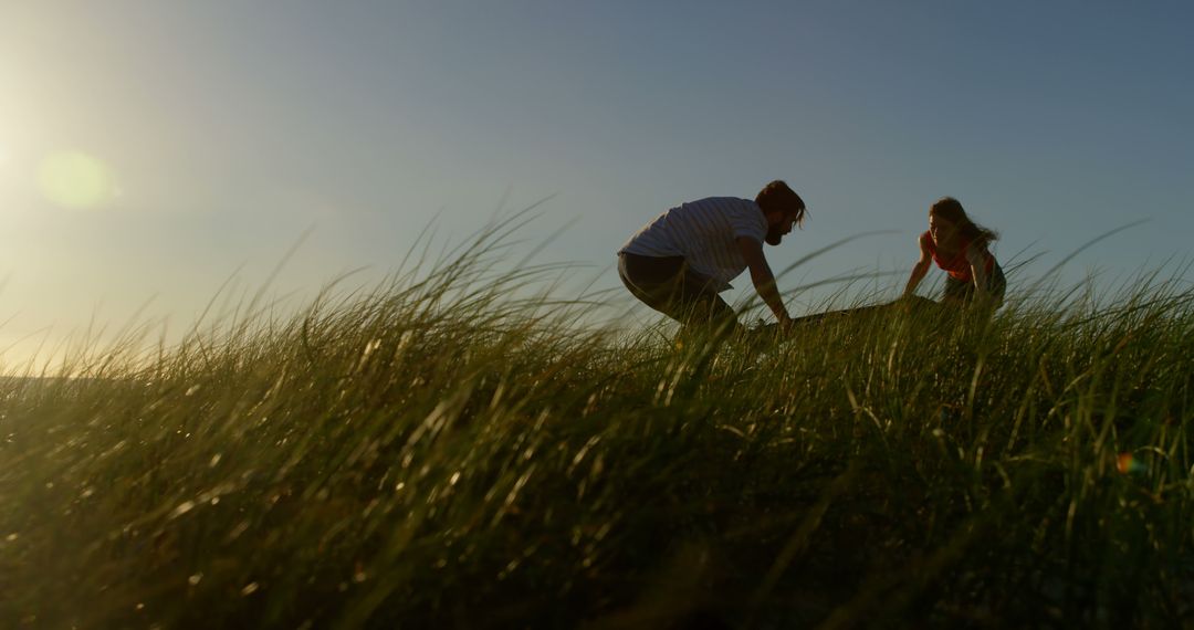 Playful Couple Enjoying Sunset in Tall Grass Field - Free Images, Stock Photos and Pictures on Pikwizard.com