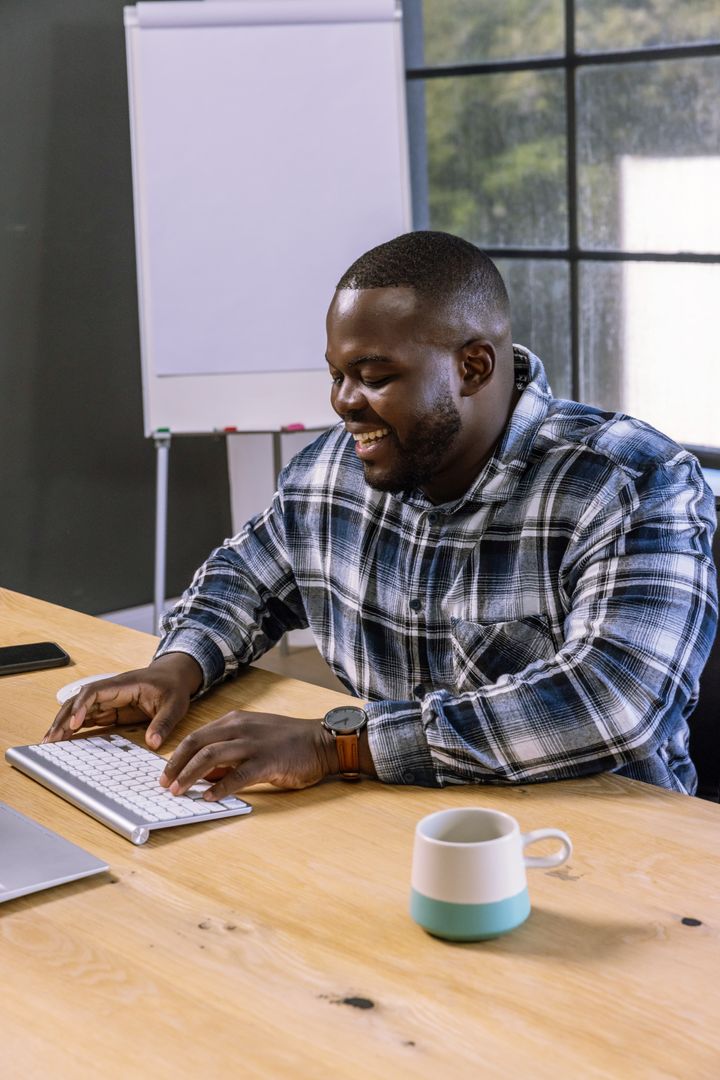 African American Man Typing on Keyboard in Modern Office