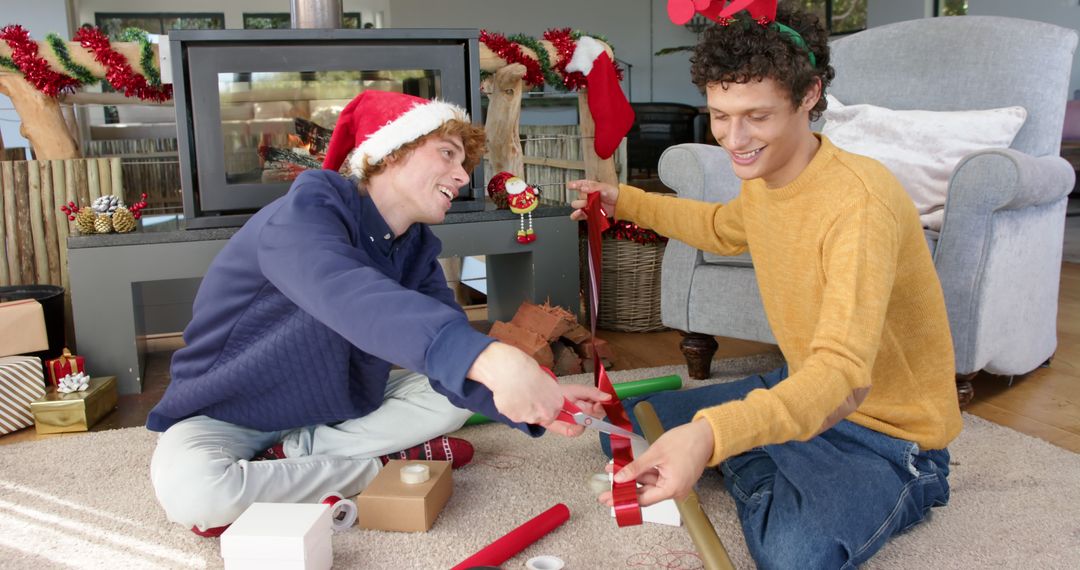 Couple Wrapping Christmas Gifts Together with Santa Hats and Decorations - Free Images, Stock Photos and Pictures on Pikwizard.com