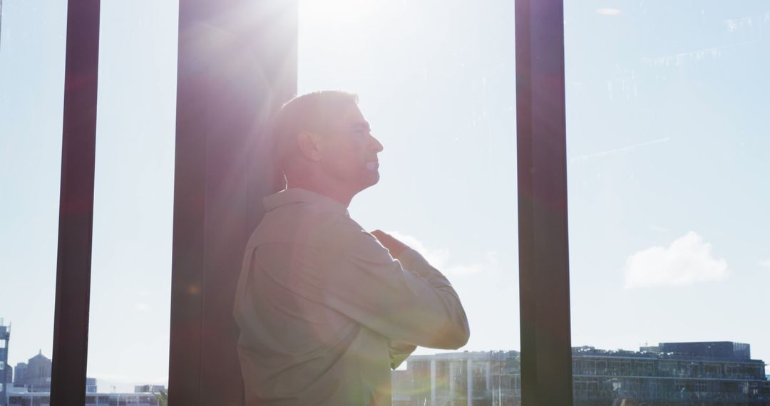 Serene Man Reflecting Next to Sunlit Window - Free Images, Stock Photos and Pictures on Pikwizard.com