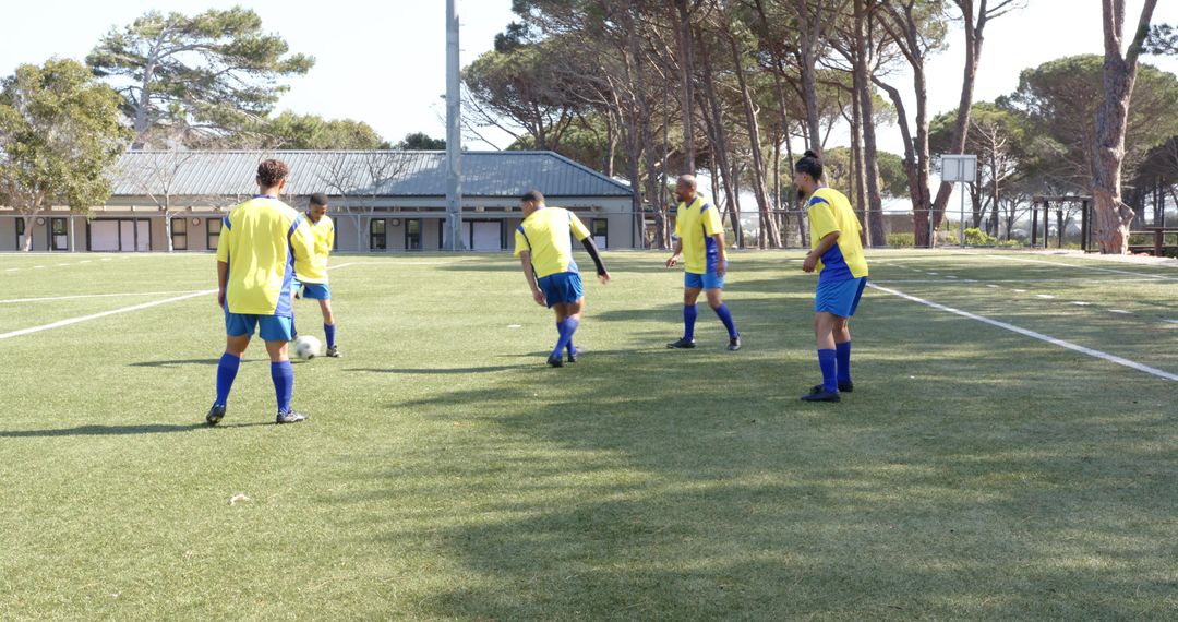 Soccer Team Practicing on Sunny Field in Matching Yellow Jerseys