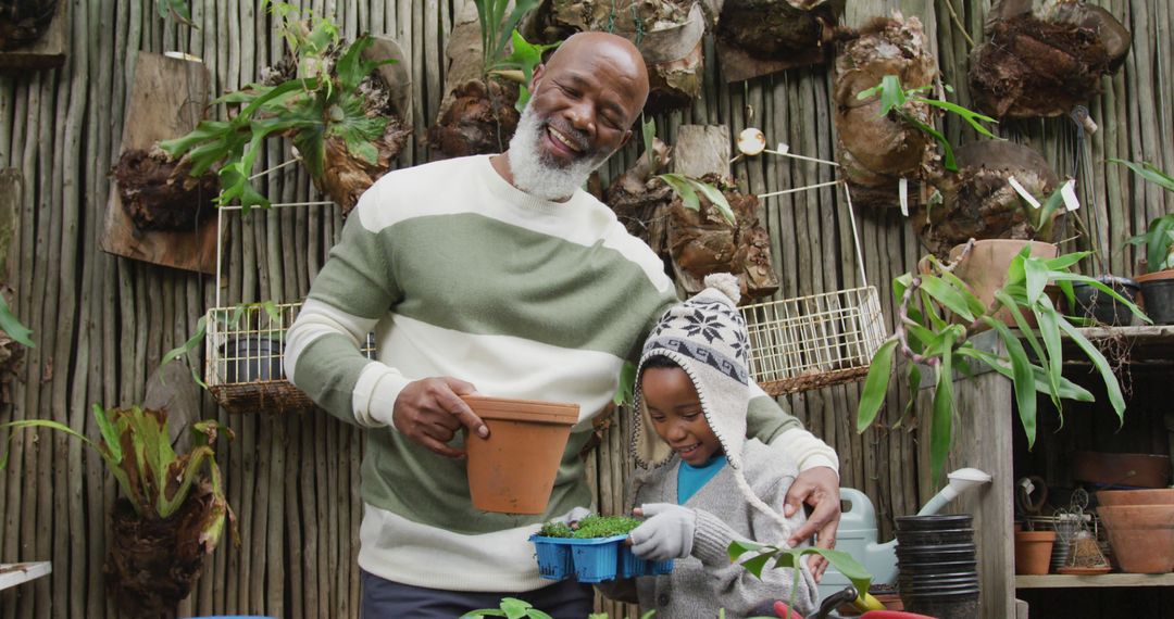 Portrait of happy senior african american man with his grandson potting up plants in garden - Free Images, Stock Photos and Pictures on Pikwizard.com