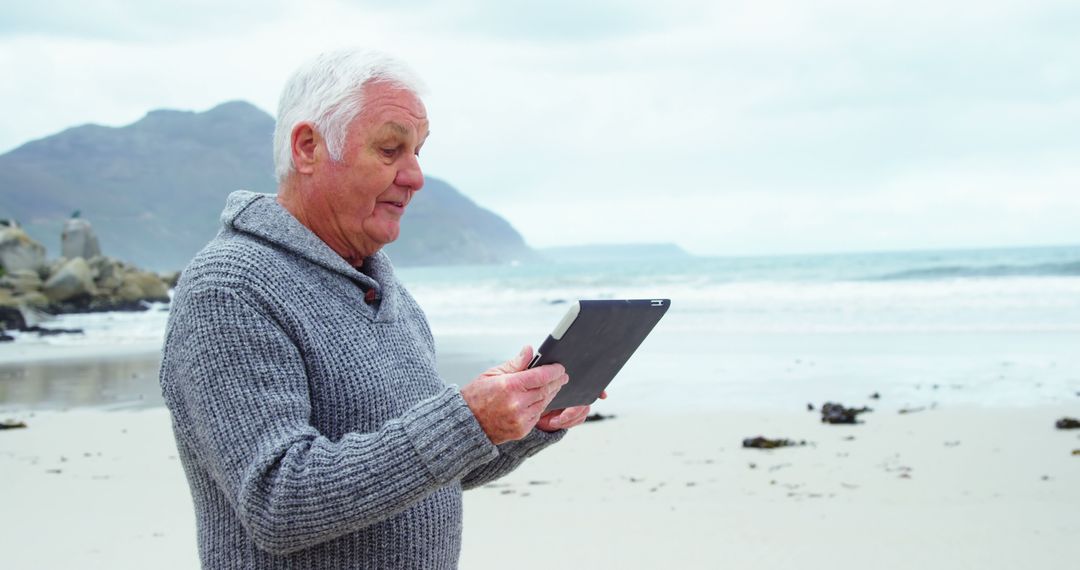 Senior Man Using Digital Tablet on Beach - Free Images, Stock Photos and Pictures on Pikwizard.com