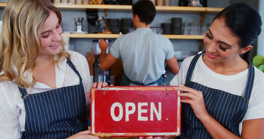 Two Baristas Holding Open Sign at Cafe Entrance - Free Images, Stock Photos and Pictures on Pikwizard.com