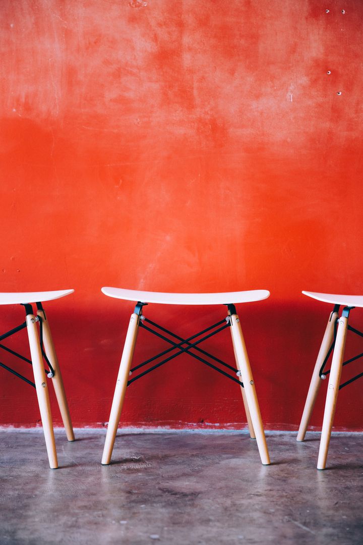 Modern Minimalist Stools Against Bold Orange Wall