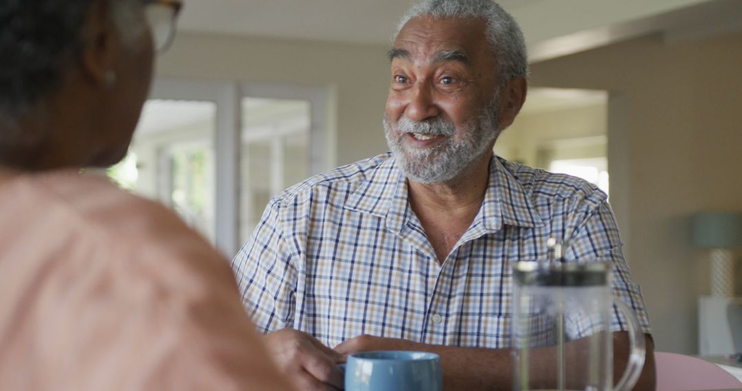 Image of happy african american senior man with coffee talking to his female partner - Free Images, Stock Photos and Pictures on Pikwizard.com