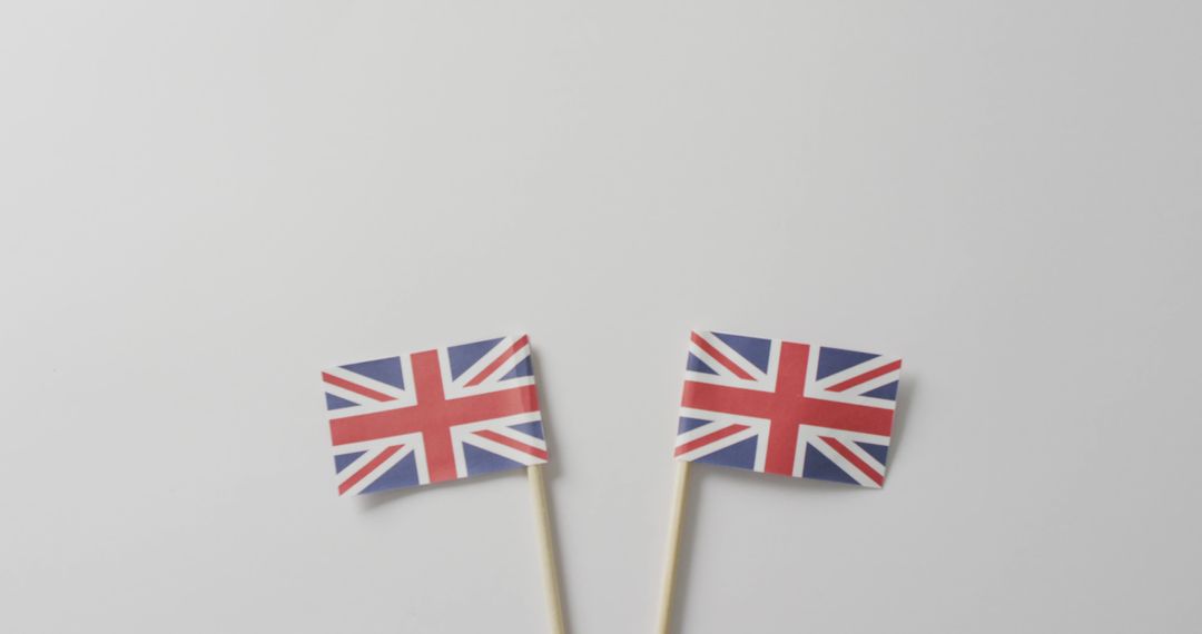 Two Small British Flags on Sticks Against White Background - Free Images, Stock Photos and Pictures on Pikwizard.com