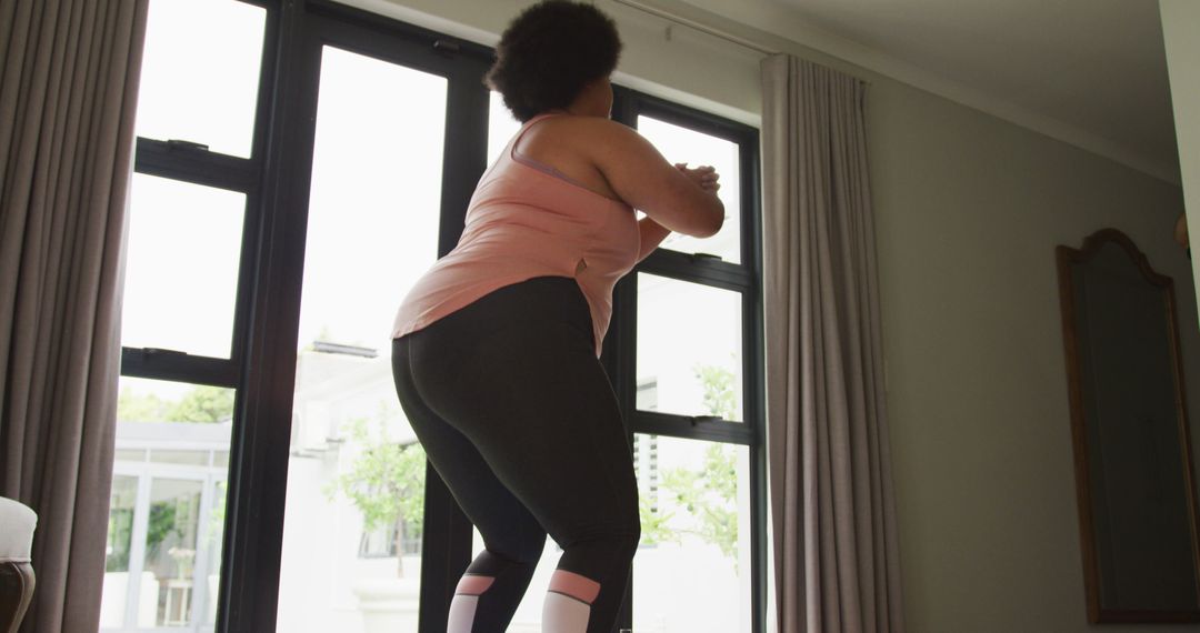 Image of plus size african american woman exercising at home, doing squats - Free Images, Stock Photos and Pictures on Pikwizard.com