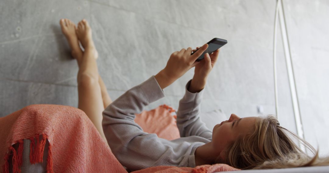 Young Woman Relaxing on Sofa Using Smartphone - Free Images, Stock Photos and Pictures on Pikwizard.com