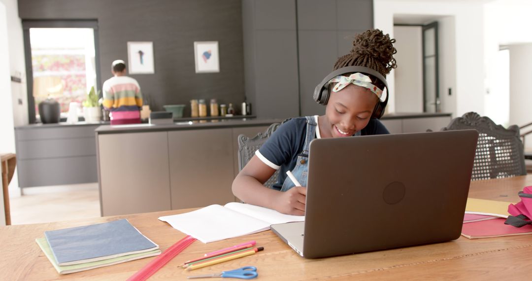 Young Girl Wears Headphones While Studying at Home with Laptop - Free Images, Stock Photos and Pictures on Pikwizard.com