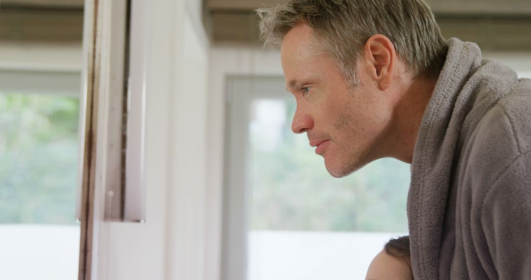 Contemplative Man Gazing Out of Window with Copy Space