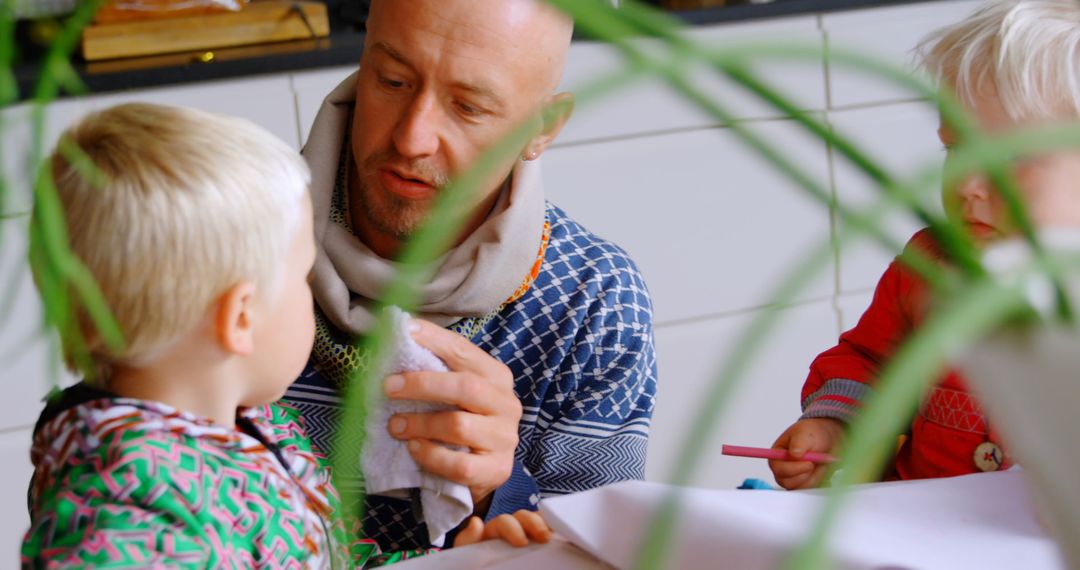 Father Tending Children During Craft Activity at Home