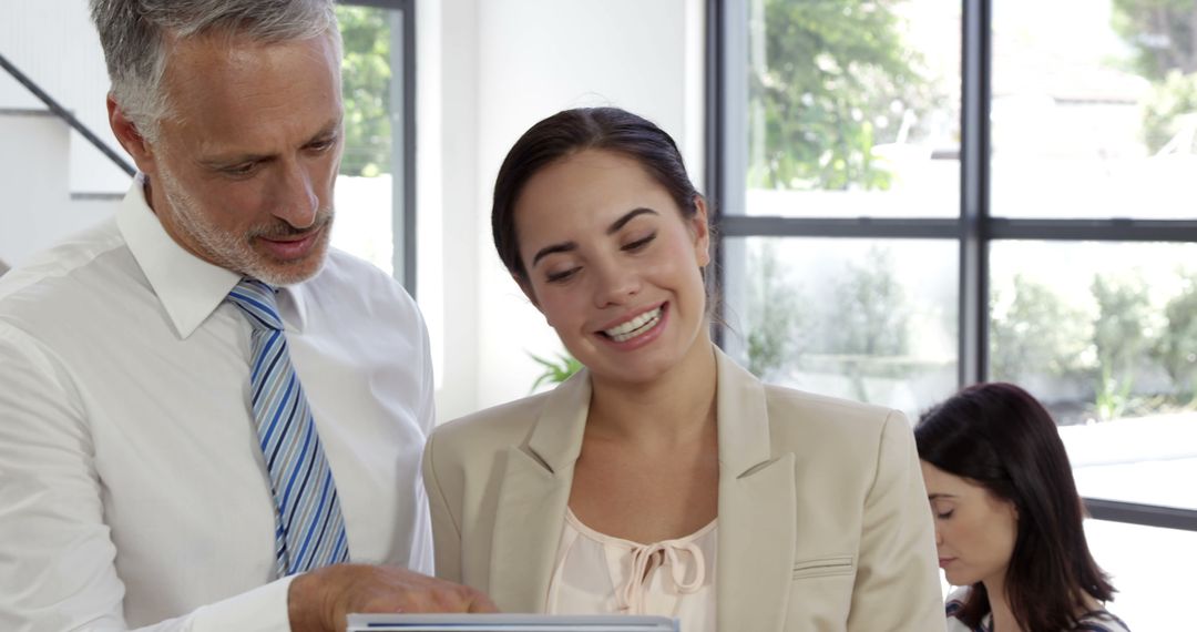 Happy Business Team Discussing Project on Tablet at Home