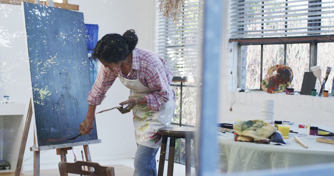 Female Artist Painting in Studio with Natural Light - Free Images, Stock Photos and Pictures on Pikwizard.com