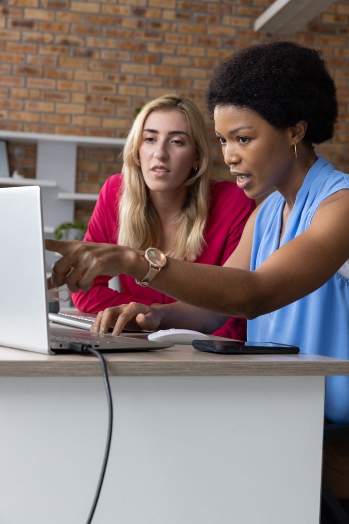Collaborative Female Coworkers Analyzing Data in Modern Office