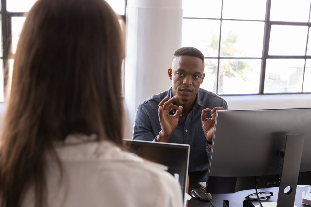 Diverse Team Engaging in Project Discussion at Office Desk